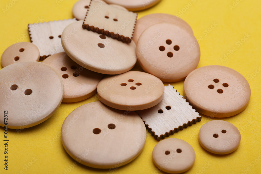 Wooden buttons on a yellow background close up Wooden buttons on a yellow background close up