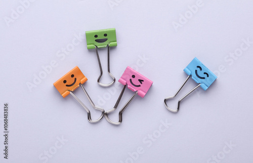 Binder clips with a smiling face on gray background. Business concept. Creative layout