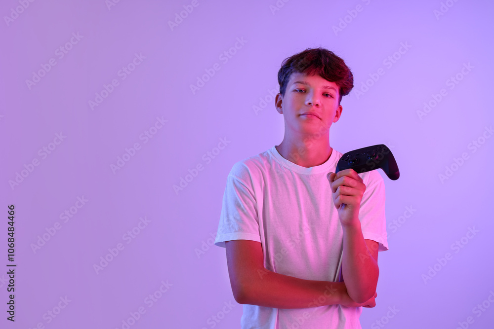 Teenage boy with controller on violet background. Space for text Teenage boy with controller on violet background. Space for text