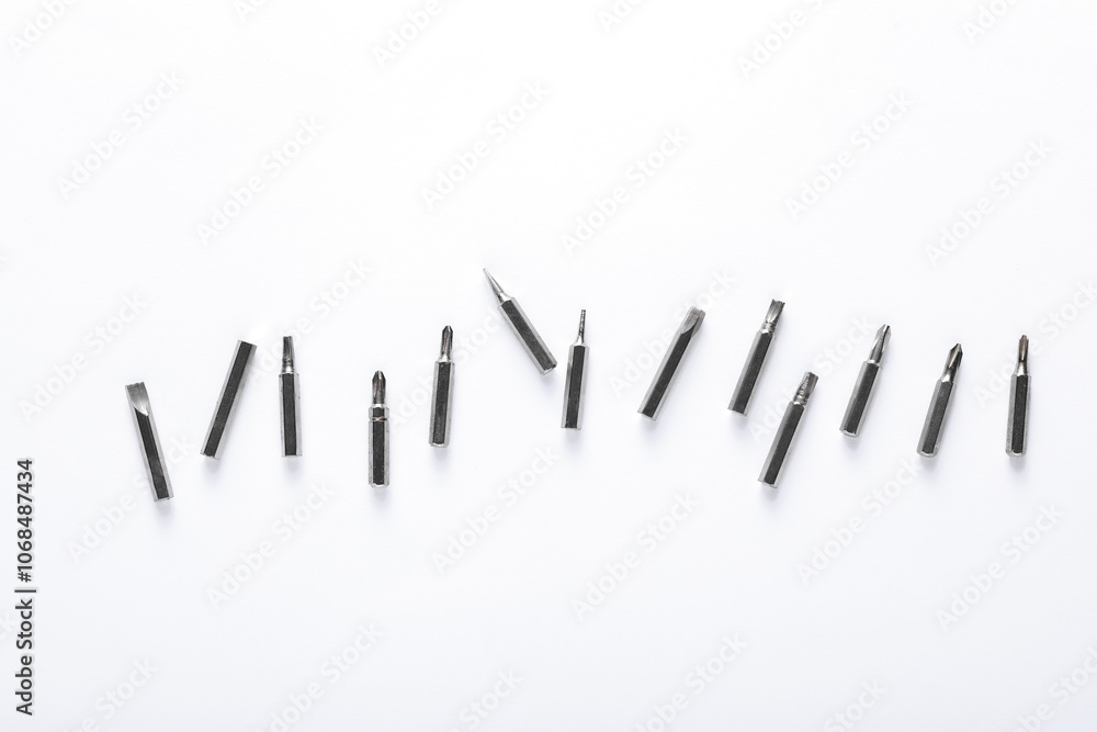 Set of metal screwdriver bits on white background Set of metal screwdriver bits on white background