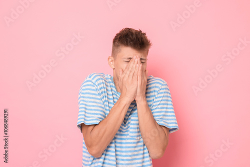 Portrait of scared young man on pink background