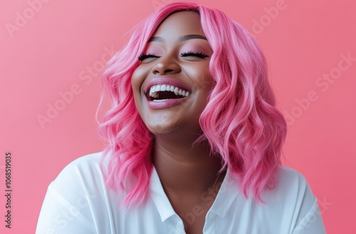 a happy woman with pink hair laughing, against a solid color background.