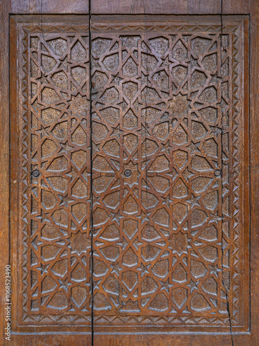 Closeup view of traditional wood carving on ancient door with intricate floral and geometric design, Hisor aka Hissar, Tajikistan photo