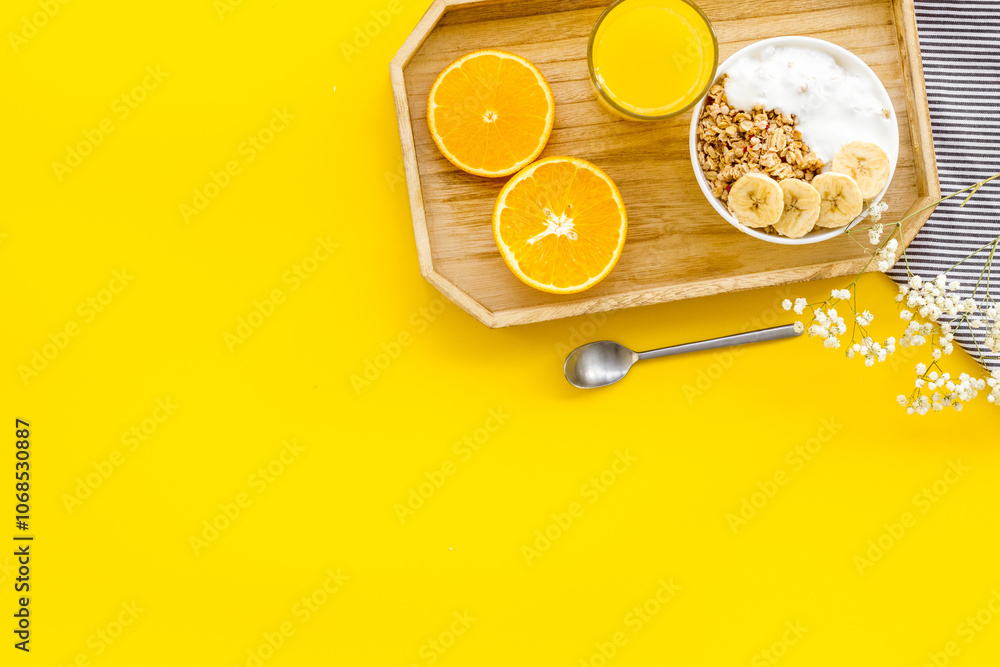 Bright breakfast with granola and orange juice on yellow background top view mockup Bright breakfast with granola and orange juice on yellow background top view mockup