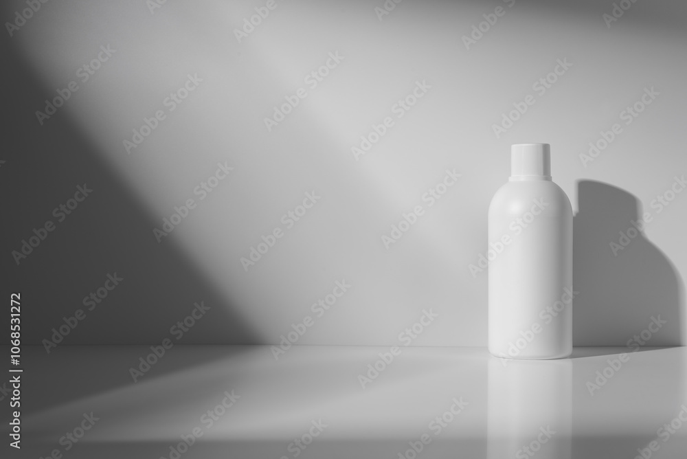 Minimalistic white cosmetic bottle mockup with shadows on a gray background Minimalistic white cosmetic bottle mockup with shadows on a gray background
