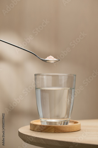 Billede på lærred A spoon of Himalayan salt is being added to a glass of drinking water, highlighting its potential health benefits