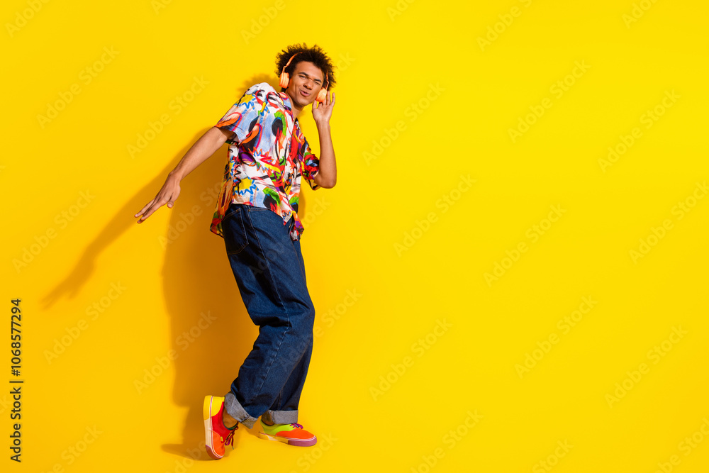 Fototapeta premium Full body portrait of nice funky young man headphones empty space wear shirt isolated on vibrant yellow color background