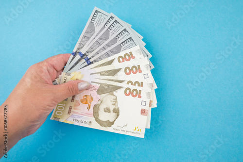 dollars and hryvnias in hand on a blue background. photo