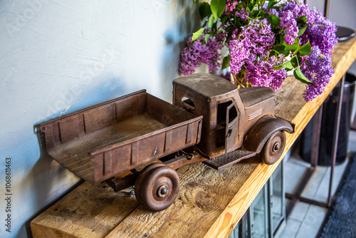 Side of an old, dirty and very rusty tin metal model toy of a dump truck photo