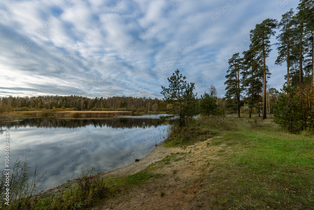 A lake with a cloudy sky in the background A lake with a cloudy sky in the background