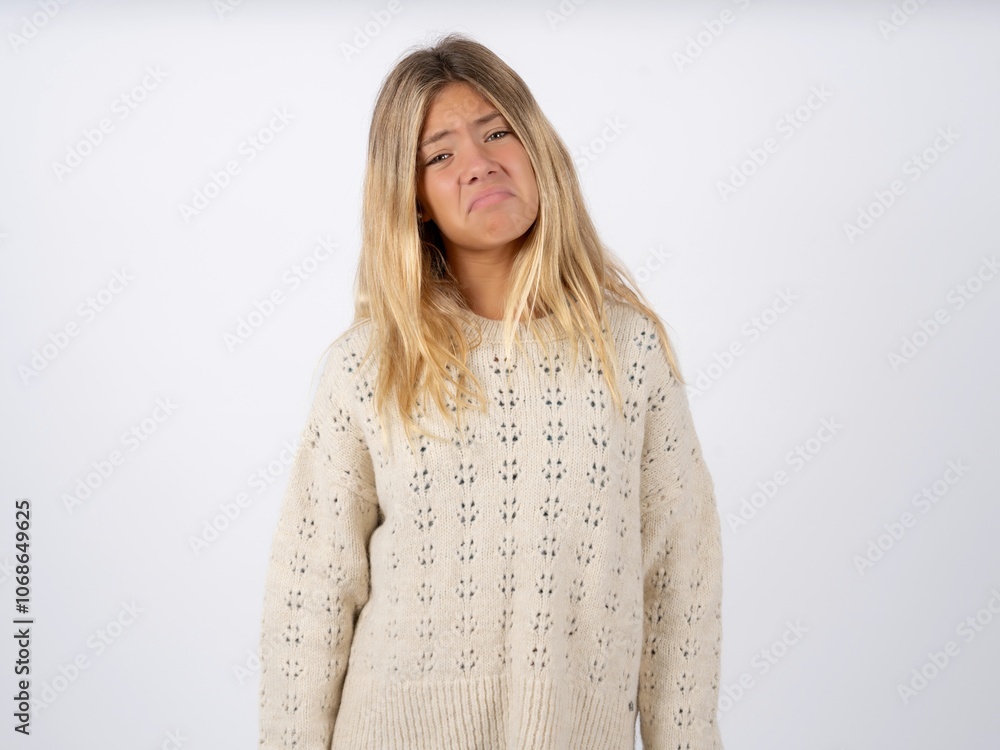 caucasian teen girl wearing knitted sweater over white depressed and worry for distress, crying angry and afraid. Sad expression. caucasian teen girl wearing knitted sweater over white depressed and worry for distress, crying angry and afraid. Sad expression.