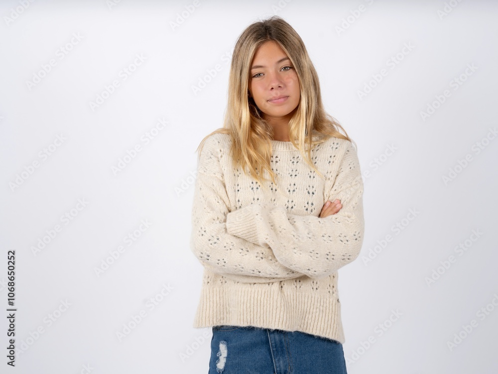 Confident caucasian teen girl wearing knitted sweater over white with arms crossed looking to the camera Confident caucasian teen girl wearing knitted sweater over white with arms crossed looking to the camera
