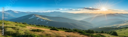 Sun setting over a vast, green mountain range.