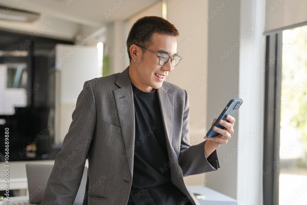 Smiling confident asian Business man using smartphone mobile addict spending time checking news technology e-commerce concept.
