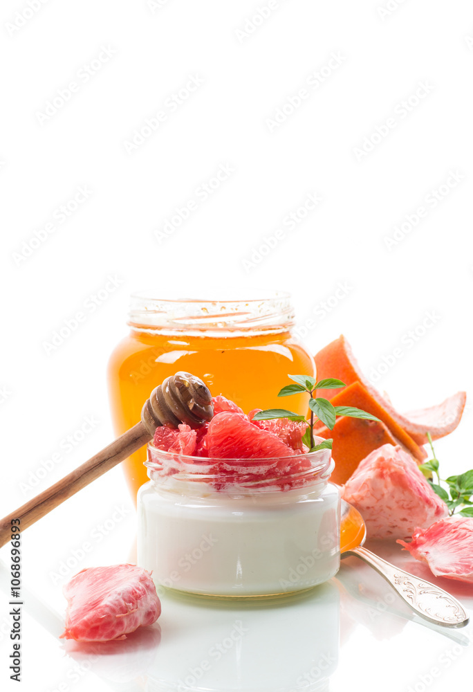 Φωτογραφία homemade sweet yogurt in a glass jar with pieces of red ripe grapefruit and hone