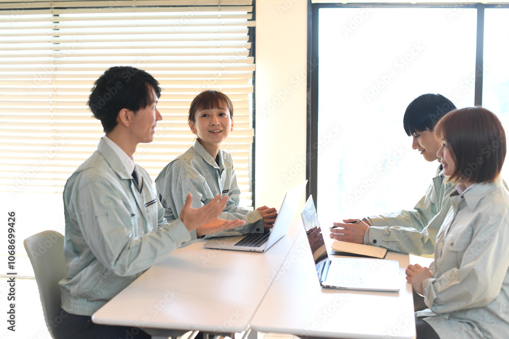 会議をする作業着姿のビジネスパーソン達
会議をする作業着姿のビジネスパーソン達