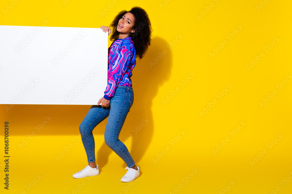Full body photo of attractive young woman hold heavy white banner empty space dressed colorful blue clothes isolated on yellow background Full body photo of attractive young woman hold heavy white banner empty space dressed colorful blue clothes isolated on yellow background
