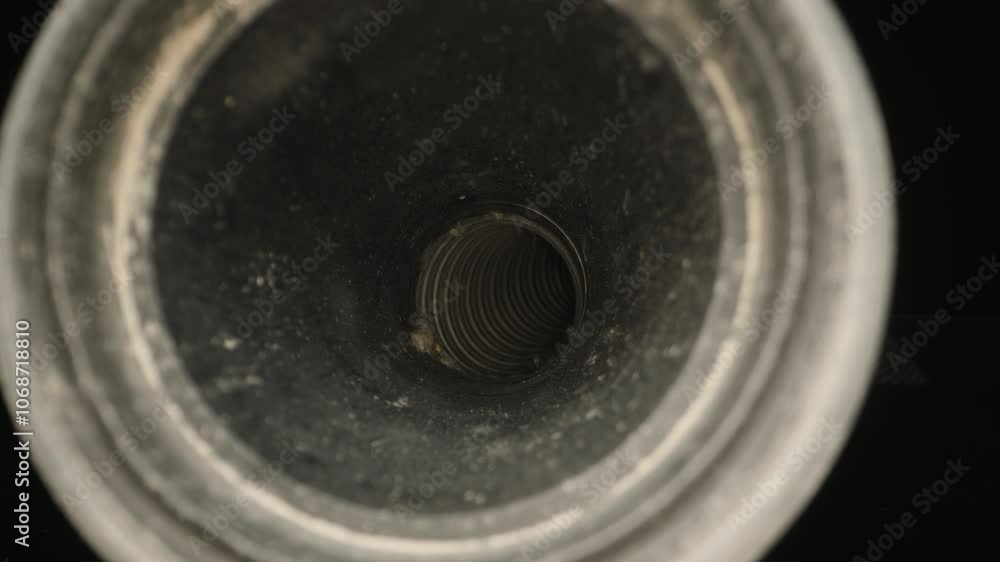 Slider. vacuum cleaner hose. View through the mouth of a blackened tube, looking into its coiled, spiral interior, with a focus on depth and texture, capturing a rugged industrial feel. Slider. vacuum cleaner hose. View through the mouth of a blackened tube, looking into its coiled, spiral interior, with a focus on depth and texture, capturing a rugged industrial feel.