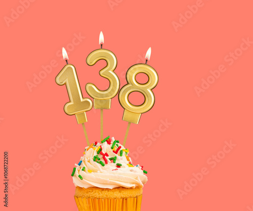 Birthday number 138 - Golden candle with cupcake