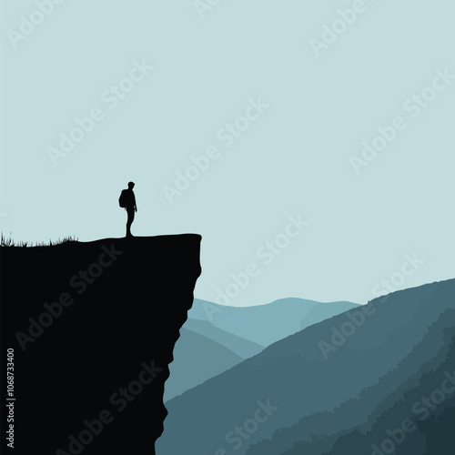 Silhouette of a hiker standing at the edge of a cliff