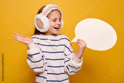 Positive happy overjoyed child with thought bubble presenting empty space for text showing free space for idea in mockup advertisement isolated over yellow background photo