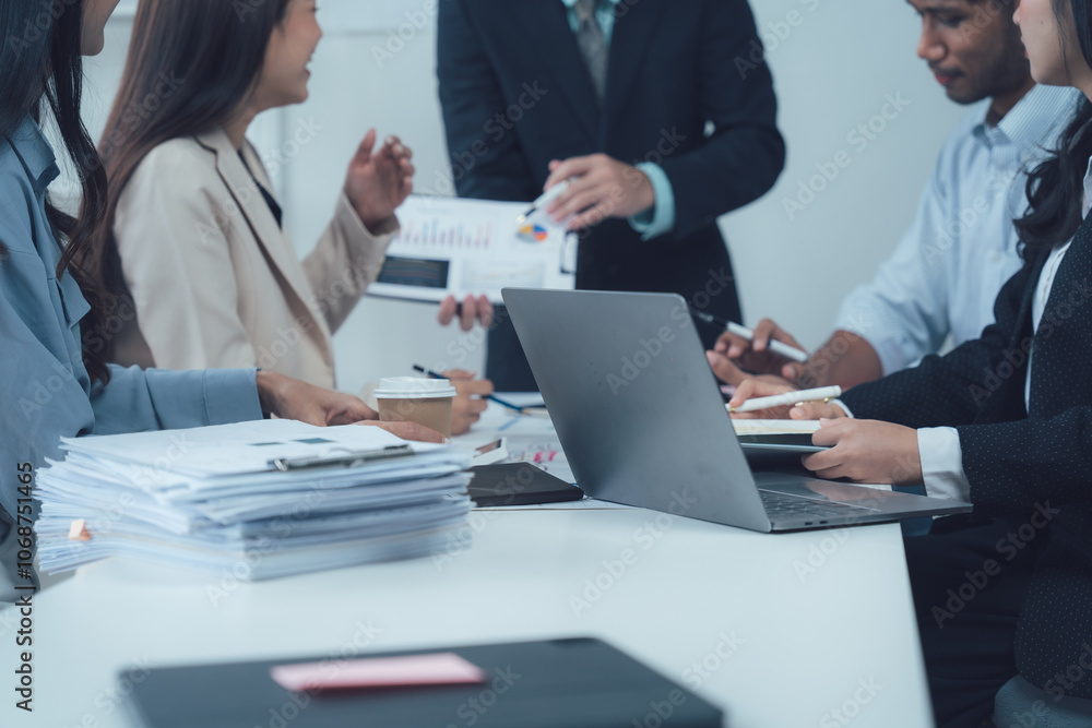 Business Meeting: A diverse group of professionals collaborate in a modern office setting. They analyze data and discuss strategies with focus and determination. Business Meeting: A diverse group of professionals collaborate in a modern office setting. They analyze data and discuss strategies with focus and determination.