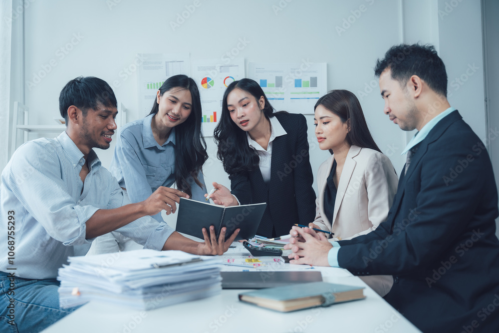 Teamwork Makes the Dream Work: A diverse group of business professionals collaborates around a table, engaged in a serious discussion over documents and charts. Teamwork Makes the Dream Work: A diverse group of business professionals collaborates around a table, engaged in a serious discussion over documents and charts.