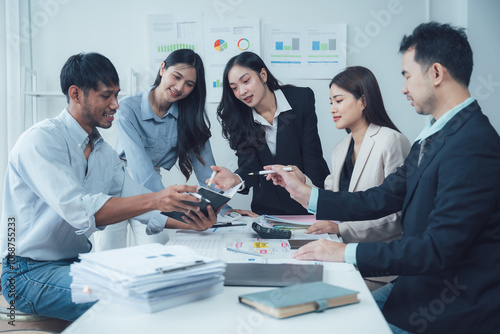 Teamwork Makes the Dream Work: A diverse group of business professionals collaborates around a table, engaged in a serious discussion and reviewing documents.