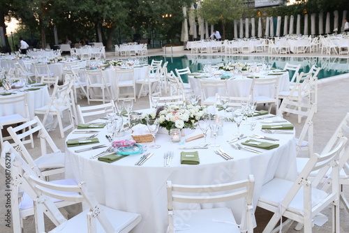 Rustic White Wedding Table Setting with Poolside View and Floral Centerpiece