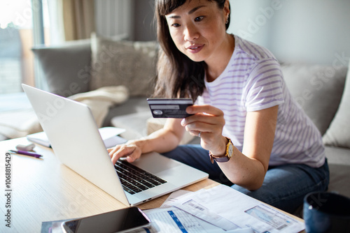 Asian woman online shopping with credit card and laptop at home photo