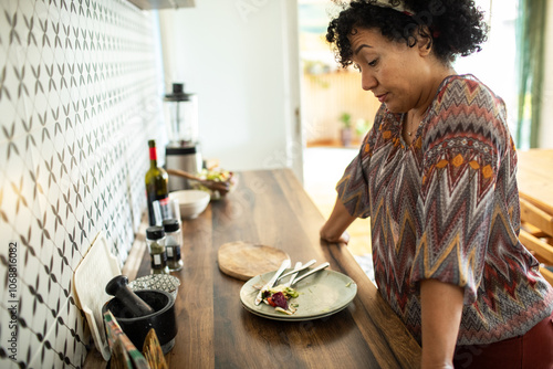 Tired woman standing over dirty dishes after meal in kitchen photo