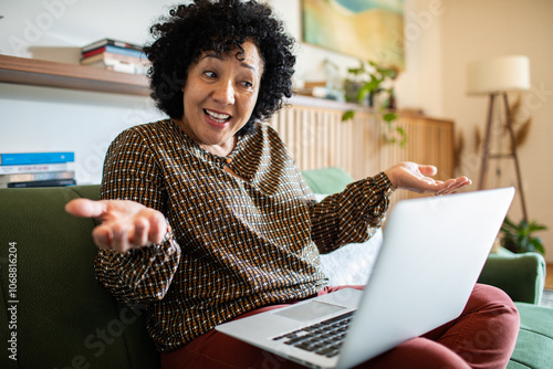 Frustrated woman on video call working from home on laptop photo