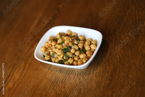 Obraz na płótnie A close-up of a delicious and healthy Turkish appetizer, featuring roasted chickpeas with herbs and spices, served in a white bowl w salonie