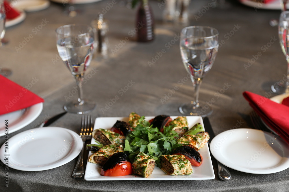 A colorful and gourmet appetizer platter featuring grilled vegetables and meat rolls, perfect for a special occasion or dinner party A colorful and gourmet appetizer platter featuring grilled vegetables and meat rolls, perfect for a special occasion or dinner party