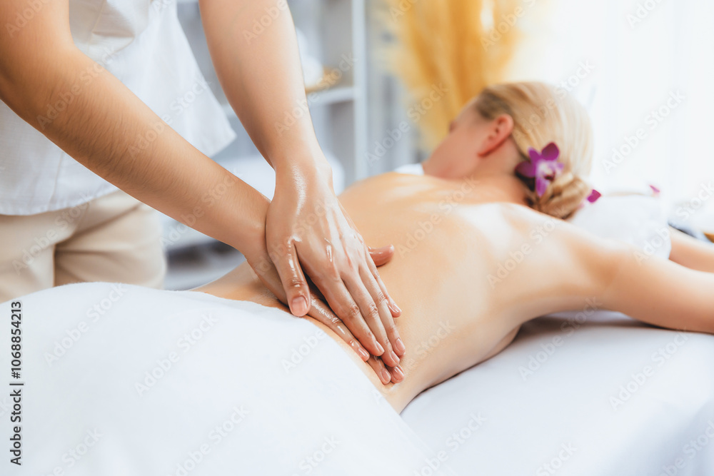 Caucasian woman customer enjoying relaxing anti-stress spa massage and pampering with beauty skin recreation leisure in day light ambient salon spa at luxury resort or hotel. Quiescent Caucasian woman customer enjoying relaxing anti-stress spa massage and pampering with beauty skin recreation leisure in day light ambient salon spa at luxury resort or hotel. Quiescent