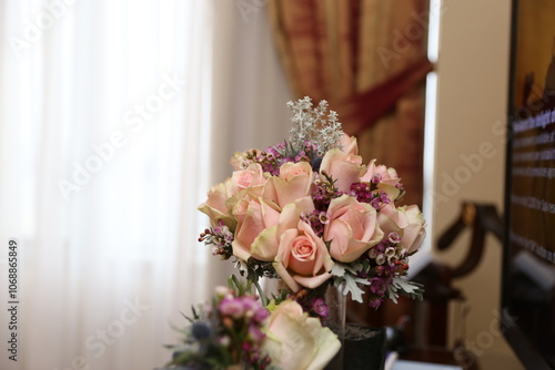 Obraz na płótnie A delicate and romantic bridal bouquet with blush pink roses and greenery, resting on a vintage piano w salonie