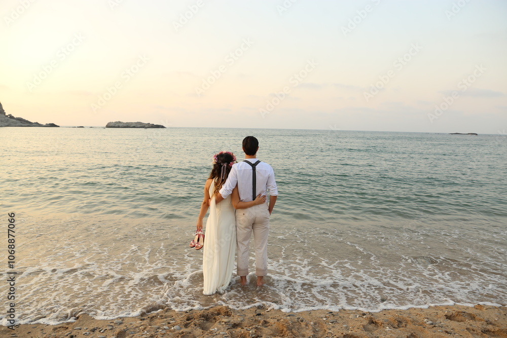 Romantic couple embracing on a serene beach at sunset, enjoying peaceful ocean views