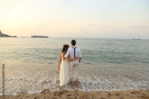 Obraz na płótnie Romantic couple embracing on a serene beach at sunset, enjoying peaceful ocean views w salonie