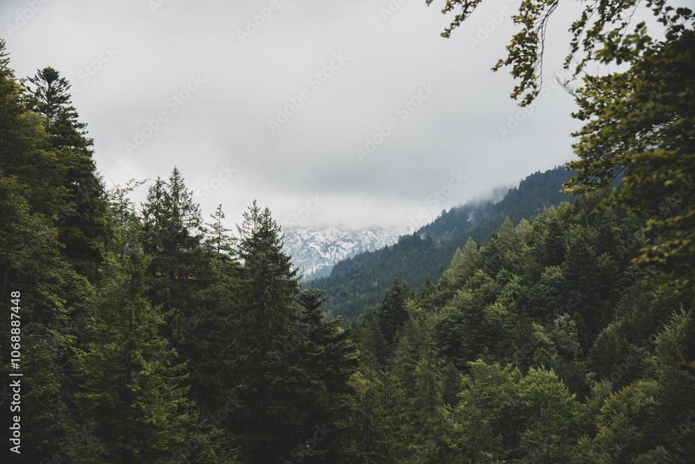 clouds over the snow peaked mountains