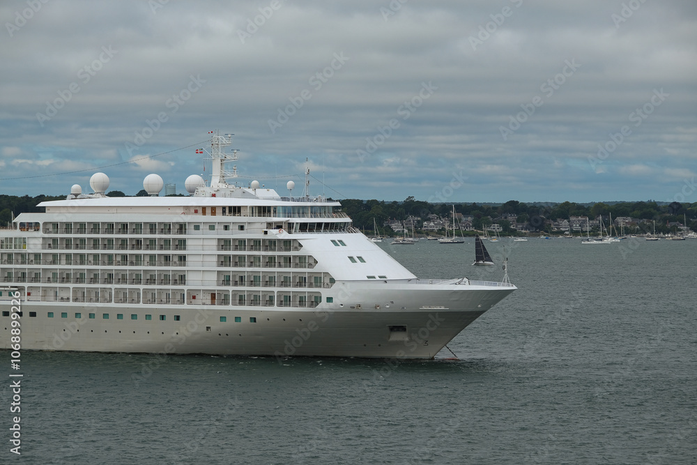 Ultra luxury all inclusive deluxe cruiseship cruise ship yacht liner Whisper or Shadow anchoring in bay in Newport, Rhode Island with New England houses, sailing boats and coastal landscape scenery Ultra luxury all inclusive deluxe cruiseship cruise ship yacht liner Whisper or Shadow anchoring in bay in Newport, Rhode Island with New England houses, sailing boats and coastal landscape scenery