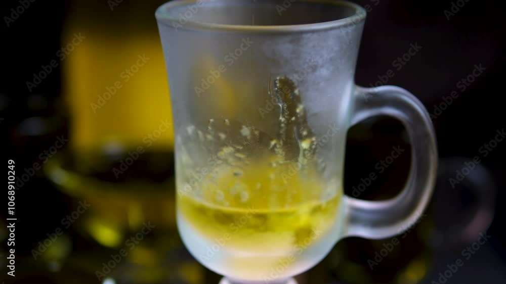 frozen olive oil flakes Crane shot of olive oil is being poured into empty beaker on grey background Abstract anti-aging cosmetics ingredients formulating concept