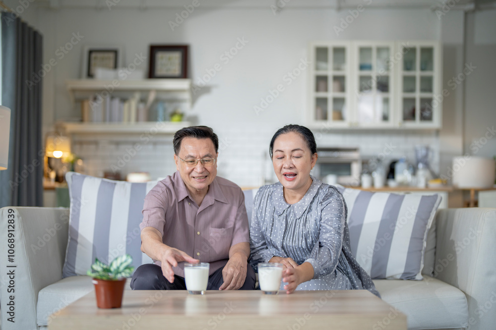 An elderly couple enjoys a peaceful moment at home, sharing smiles and drinks. The warm and cozy atmosphere emphasizes their deep connection, happiness, and the comfort of spending time together. An elderly couple enjoys a peaceful moment at home, sharing smiles and drinks. The warm and cozy atmosphere emphasizes their deep connection, happiness, and the comfort of spending time together.