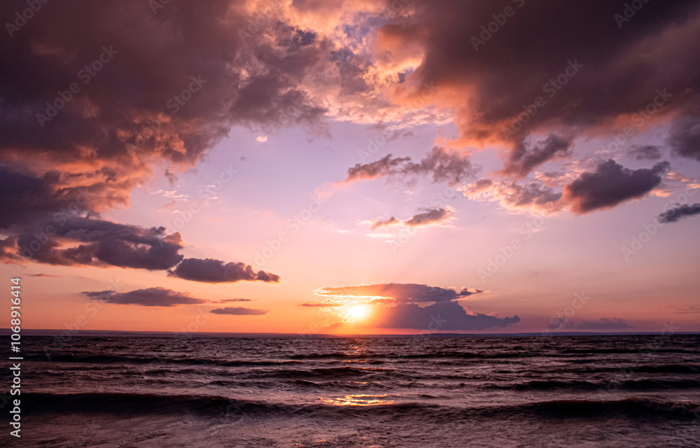 Obraz premium Sunset sky over sea waves.