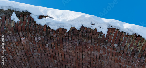 A fragment of a brick wall covered with snow