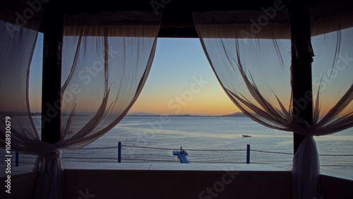 Fotografija Open sea view through sheer curtains at sunset
