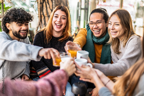 People talking and having fun together at cappuccino restaurant - Friends group toasting latte at coffee bar patio - Life style concept with happy guys and girls at cafe terrace at winter time
