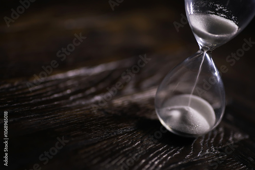 Close-Up of Hourglass on Dark Wooden Surface Symbolizing Time Passing, Business Deadlines, and Life's Transience