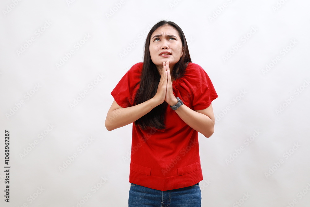 Young hispanic woman wearing casual red shirt begging and praying with hands together with hope expression on face very emotional and worried. begging. Young hispanic woman wearing casual red shirt begging and praying with hands together with hope expression on face very emotional and worried. begging.