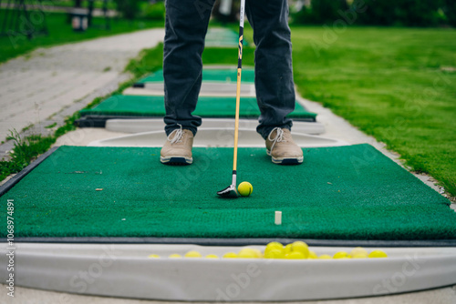 Golfer playing adventure or mini golf and trying putting ball into hole. Sports and leisure activity