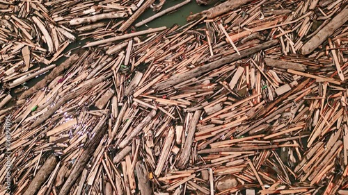 Aerial view of large log jam, driftwood accumulation, floating wood debris at river. Logs and branches clog waterway in forest. Eco issue, waterway blockage. Drone shot photo